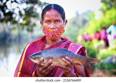 Odisha, India - February 25th 2022: Selective Focus On Tribal Women Of Women Self Help Group SHG Holding Fresh Rohu Carp Fish In Hand In Nice Blur Background