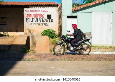 Oeiras, Brazil - Circa May 2019: Older Man Riding His Motorcycle Using A Plastic Beer Crate As A Motorcycle Trunk