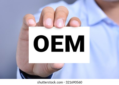 OEM letters (or Original Equipment Manufacturer) on the card shown by a man