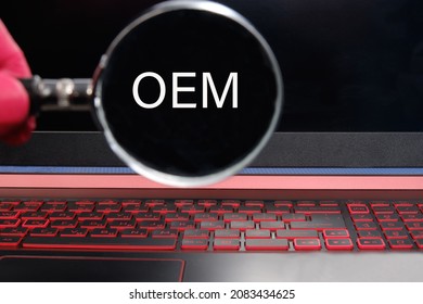 OEM or Original equipment manufacturer text on the monitor through a magnifying glass.