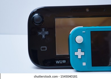 O'Fallon, Missouri / USA - October 25 2019: Partial Image Of A Nintendo Switch Lite In Front Of A Nintendo Wii U Gamepad On A White Background.