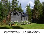 Off Grid Tiny House on Wheels in Forest Clearing surrounded by Flowers