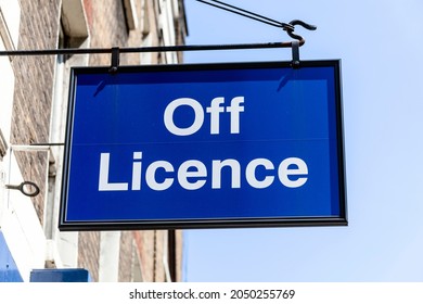 Off Licence or liquor store blue advertising logo sign outside the entrance to an alcohol retail business selling bottle beer and wine, stock photo image