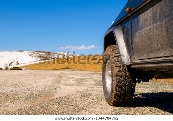 Off road 4x4 car\
in the snowy mountains on a sunny day. Off-road traveling, all\
terrain vehicle in nature