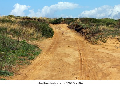Off road sand dune motocross and auto sport track on blue sky and white clouds background