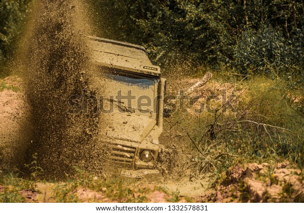 Off\
road sport truck between mountains landscape. Mudding is\
off-roading through an area of wet mud or clay. Mud and water\
splash in off the road racing. 4x4 travel\
trekking