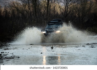 Off Road Vehicle Coming Out Of A Mud Hole Hazard, Mud And Water Splash In Off-road Racing. Scene Of Wather Splash In Off-road Racing. Offroad