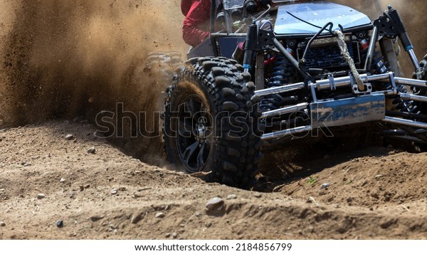 Off road vehicle motion the wheels tires off road\
dust cloud in desert, Offroad vehicle bashing through sand in the\
desert, off oad racing.