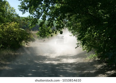 Off road vehicle moving in cloud of dust from previous car.