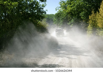 Off road vehicle moving in cloud of dust from previous car.