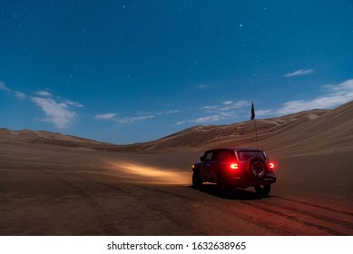 Off Roader Car With Lights On Stopped In The Desert At Night Under The Moonlight With Stars And Clouds In The Sky, Dasht E Lut Or Sahara Desert, Ads Space