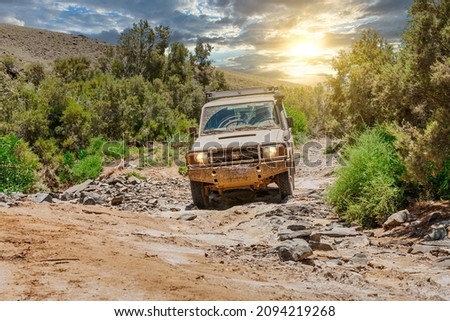 Off roading with an all terrain vehicle through a dry riverbed in The Arkaroola Wilderness Sanctuary located in the ruggedly spectacular northern Flinders Ranges