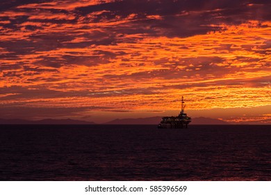 Off Shore Oil Rig Silhouetted In The Evening Sunset