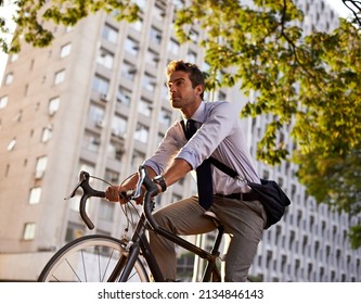 Off to work on his wheels. Shot of a businessman commuting to work with his bicycle.