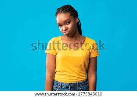 Offended African American Girl Sulking Looking At Camera Standing Over Blue Background. Studio Shot