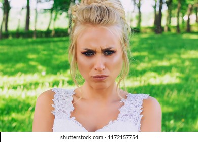 Offended and angry bride frowns looking at camera. Emotional model.