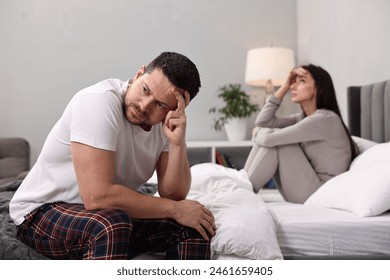 Offended couple ignoring each other after quarrel in bedroom, selective focus. Relationship problems - Powered by Shutterstock