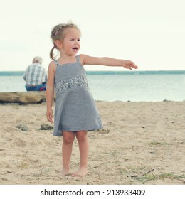 offended crying little girl on the beach. sad little girl with blond hair