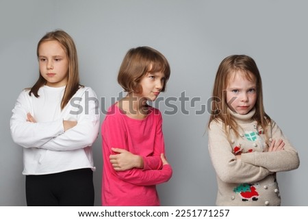 Offended displeased children friends with crossed arms. Young girls 8-10 years old portrait