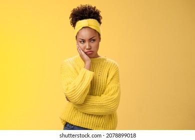 Offended gloomy grumpy pouting young african-american girlfriend feel irritated jealous frowning bothered sulking look away insulted unwilling talk somebody lean hand head standing yellow background