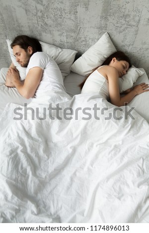 Offended lovers sleep separately in bed back to back, young lovers have sexual problems, avoid intimacy in bed, indifferent couple not talking after fight. Concept of bad relationship, no sex
