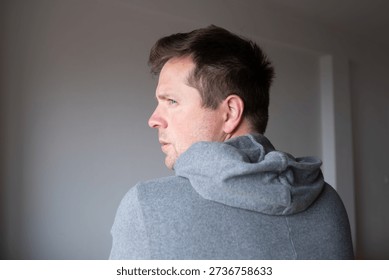Offended man turning his back and looking back over his shoulder with resentment