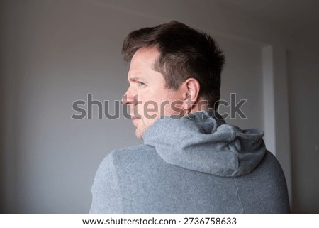 Offended man turning his back and looking back over his shoulder with resentment