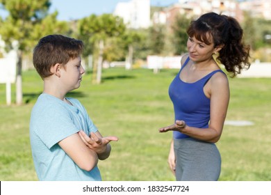 Offended Tween Boy Standing On Sports Ground While Mom Scolding Him