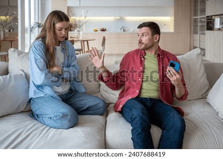 Offended upset woman feels lonely talking to husband who brushes off, does not want to resolve difficulty in relations, hides mobile phone. Exhausted from stress wife, drooping, communicates with man