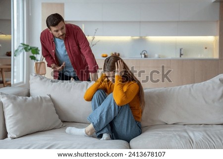 Offended woman closed ears sitting on home couch while man scream talk in family quarrel scandal. Upset wife and husband have misunderstanding, toxic relationships. Marital discord, emotional violence Foto stock © 