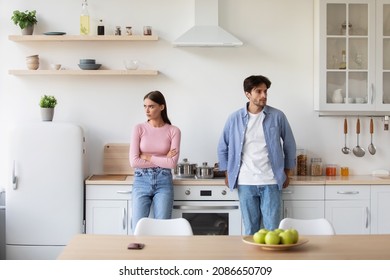 Offended young man ignore lady on kitchen interior. Negative emotions, relationship problems at home, quarrel and self-isolation, conflicts in marriage, couple after fight dispute, deciding to divorce - Powered by Shutterstock