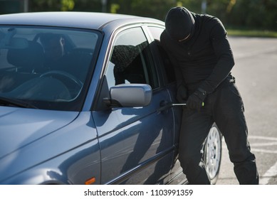 Un agresor con ropa negra y máscara está tratando de robar un camión en un estacionamiento. Detengan la criminalidad.