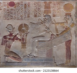 offering scene showing Pharaoh Seti I in front of Osiris and Isis at Abydos Temple. Egypt.