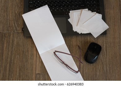 Office accessories on the table: computer, notebook, mouse, glasses