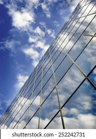 Office building details reflecting blue sky and clouds in windows