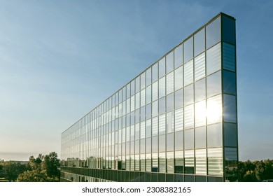office building facade with sky reflections. modern glass building at sunset against blue sky. drone photo.