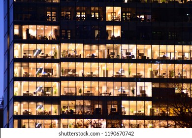 Office Building At Night. Late Night At Work. Glass Curtain Wall Office Building