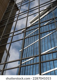 An office building reflected in the mirror surface of another office building.