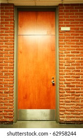 Office Building Or School Wood Door In Olive Green Metal Frame In Terra Cotta Brick Wall.