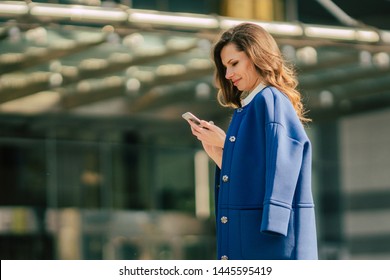 Office buildings city people in suit. Caucasian businesswoman using smartphone with hand. Business concept. Portrait stylish business woman in fashionable clothes holding Phone near office building. - Shutterstock ID 1445595419