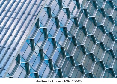 Office buildings. Structure of hexagon windows in futuristic technology network connection concept. Blue glass modern architecture facade design with reflection of sky in urban city, Downtown.