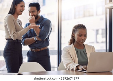 Office bully, woman and working at laptop with coworkers laughing in a corporate workplace about gossip. Young black person typing on a computer with internet and joke with staff being mean at desk