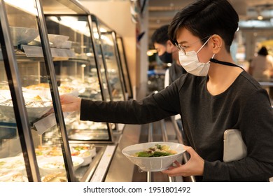 Office Cafeteria Safety In The COVID-19 Pandemic. A Smart Look Asian Working Woman With Face Mask Picked Her Lunch In A Canteen. New Normal, Stop The Spread, Protocol, Restaurant, Food Court. Concept.