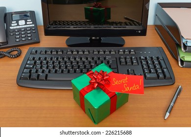 Office Christmas Secret Santa Gift Wrapped Present And Tag On A Desk
