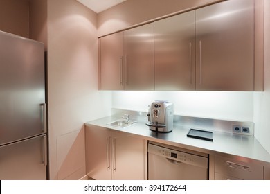 Office Chrome Kitchen  Interior With Sink, Fridge And Coffee Machine