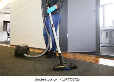 Office Cleaning: Cleaner Vacuums The Corridor Of An Office