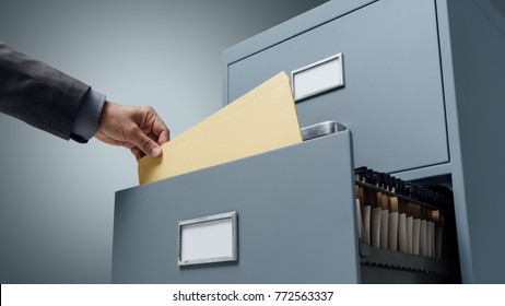 Office clerk searching files in a filing cabinet drawer, business administration and data storage concept