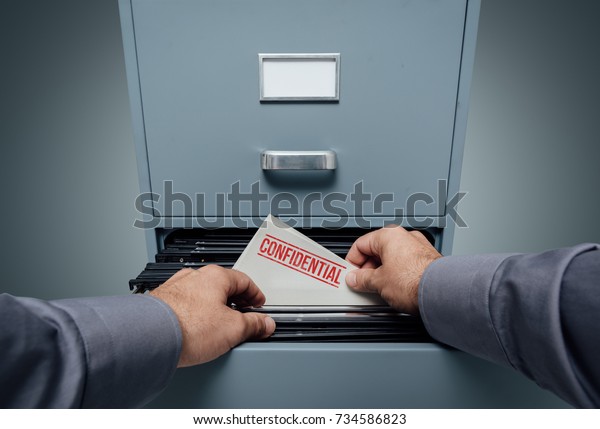 Office clerk searching for files in the filing\
cabinet, he finds a folder with confidential information inside,\
personal point of view