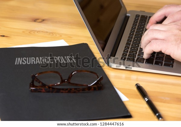 An\
office, computer and a folder with insurance\
policy