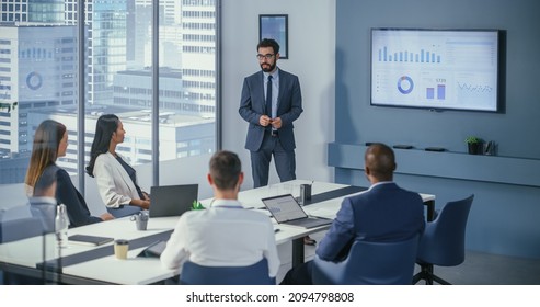 Office Conference Room Meeting: Digital Enterpreneur Presents e-Commerce Investment Strategy for Group of Investors. Wall TV Showing Big Data Analysis, Infographics, Stock Market Information, Trends - Powered by Shutterstock